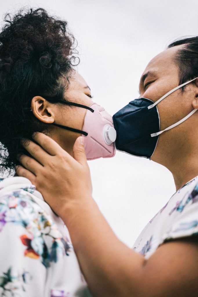 Couple With Face Masks Kissing